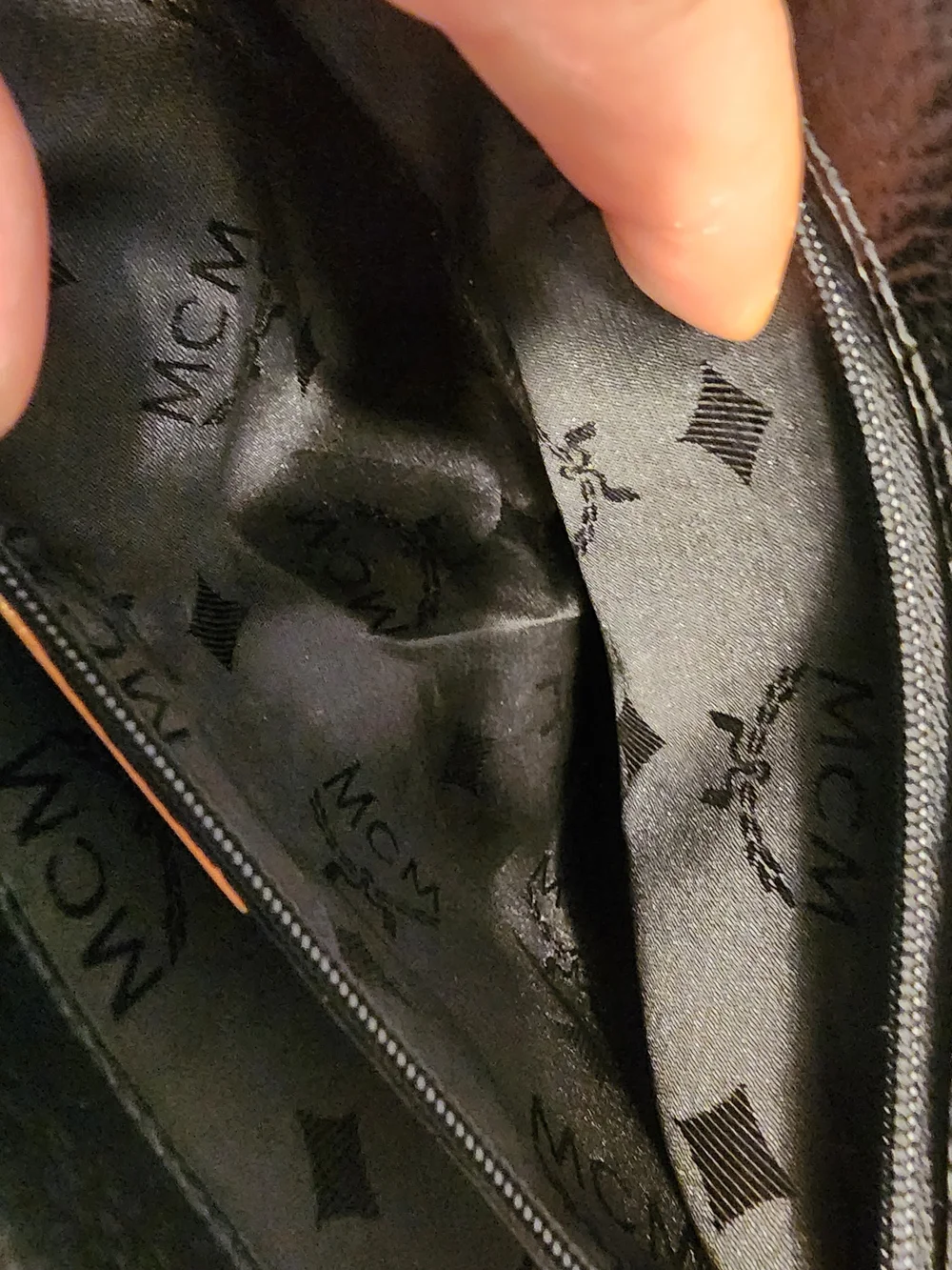 vintage MCM black pebbled leather studded crossbody bag featuring a front plaque